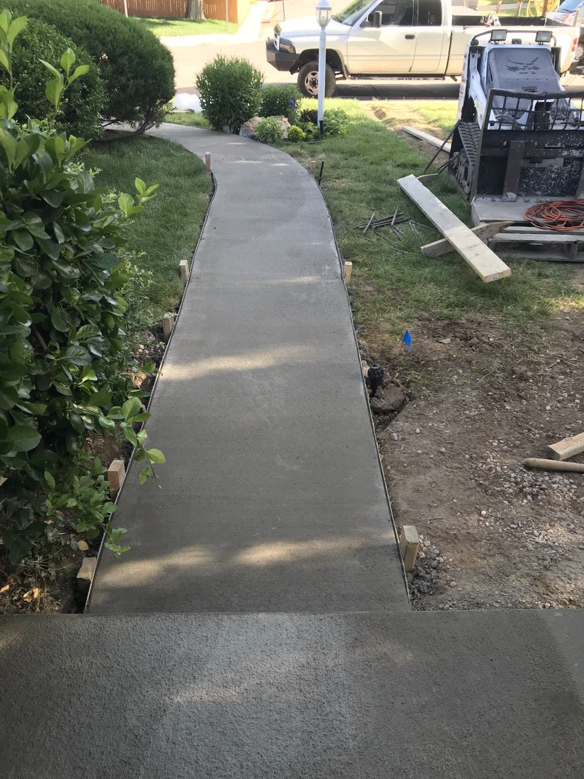 New concrete walkway graded away from a house