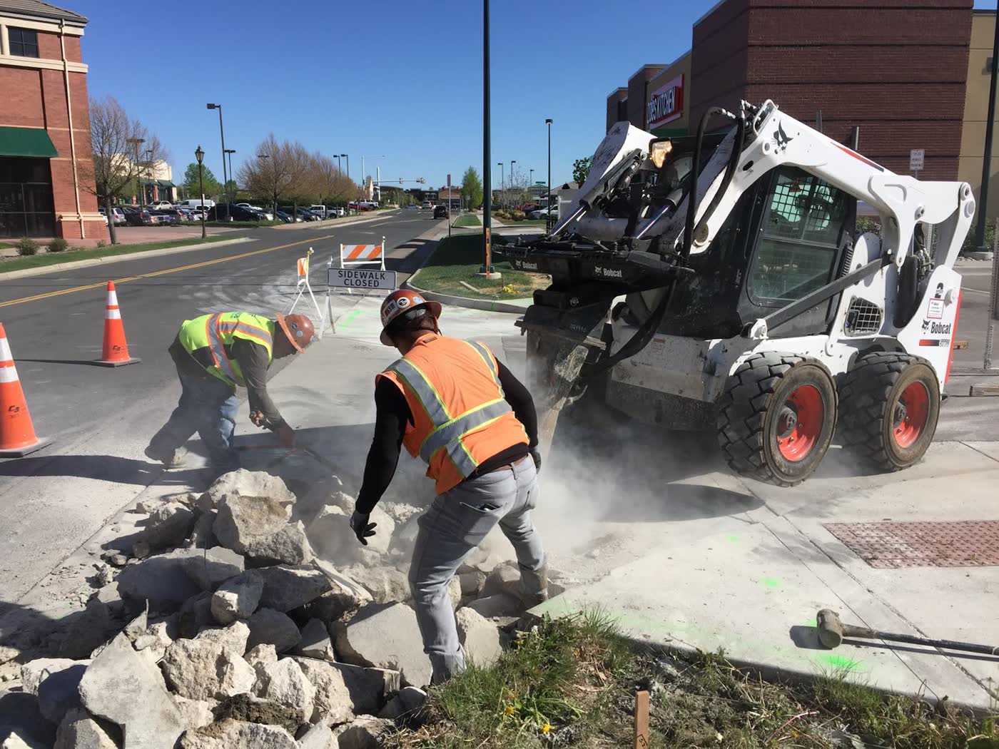 Crew removing broken concrete with a track loader
